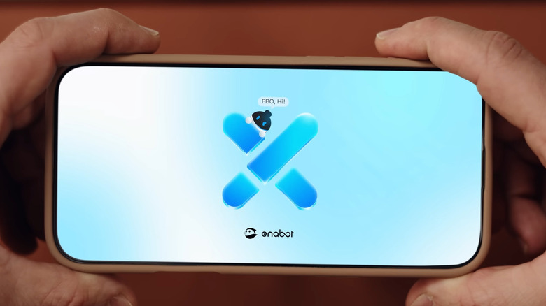 Hand holding phone showing Enabot mobile app