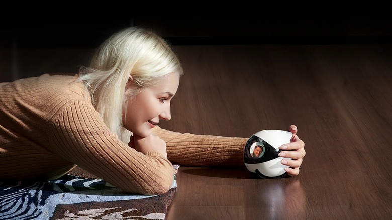 Woman holding Enabot security camera while on video call