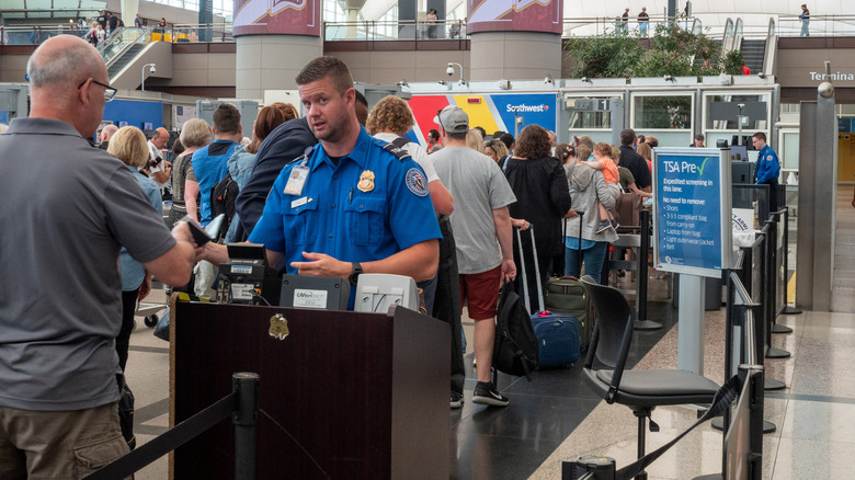 TSA agent looking at man's ID