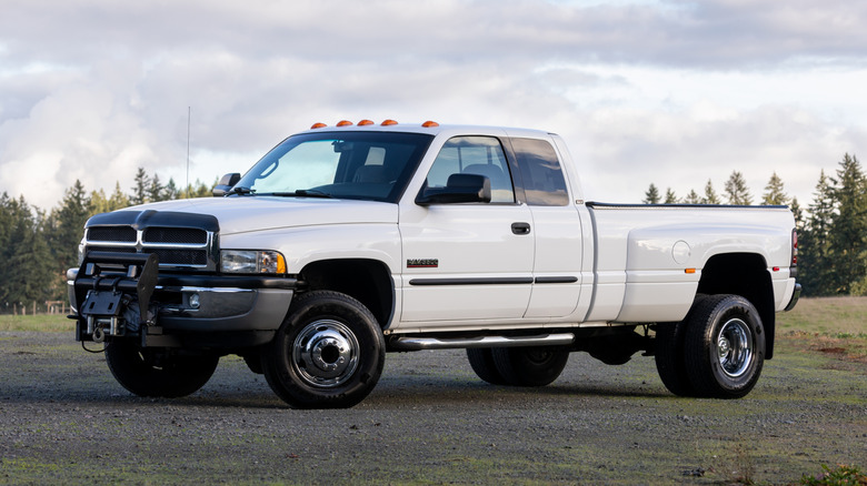 White 1990s Dodge Ram Cummins truck parked on gravel