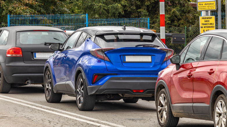 Three stationary cars lined up on a road.