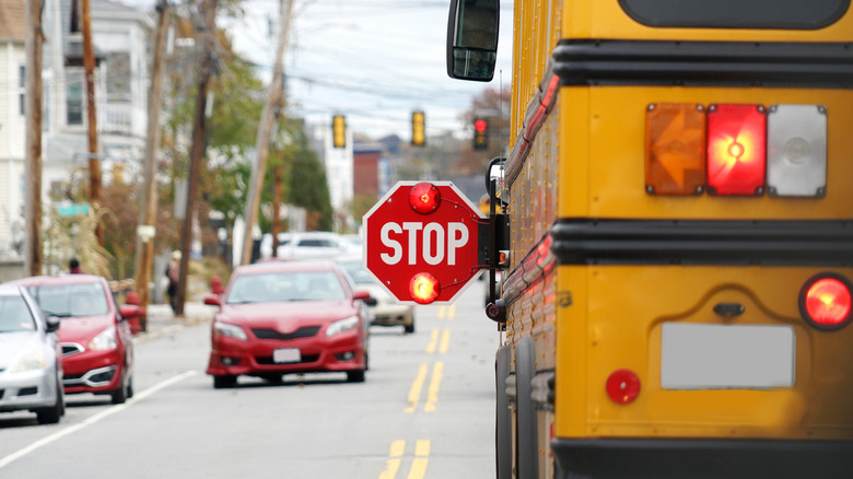 Rear view of a stopped school bus with stop sign extended.