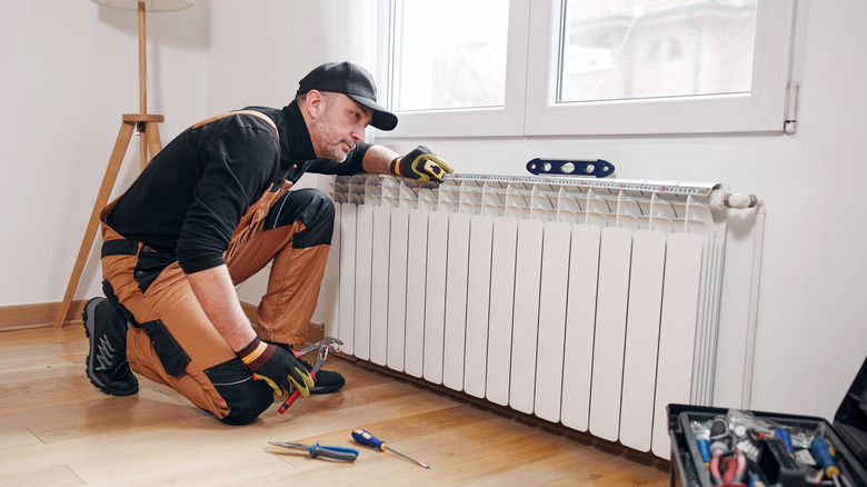 A mechanic fixing a home radiator