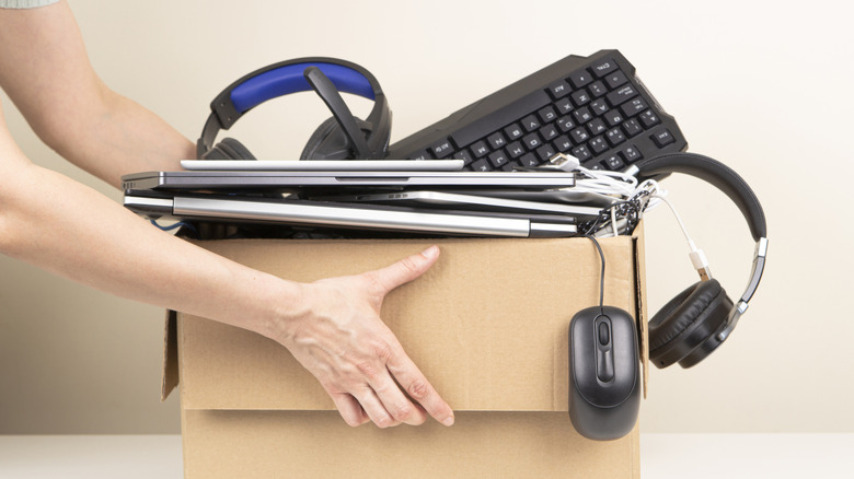 A woman holding a box of electrical goods