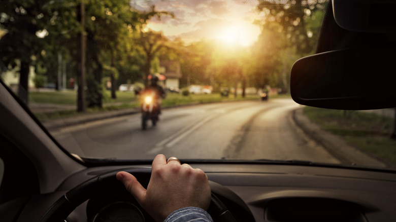 Car approaching motorcycle from opposite direction
