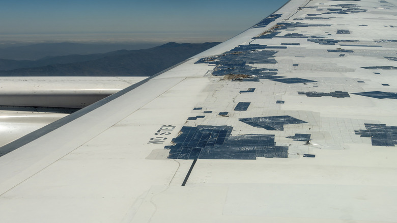 A close up of a airplane wing plastered with speed tape