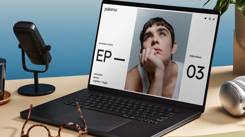 Laptop on wooden desk open to website with picture of man