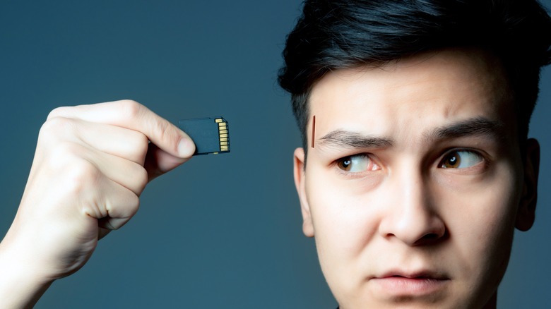 Picture depicts someone inserting chip into brain