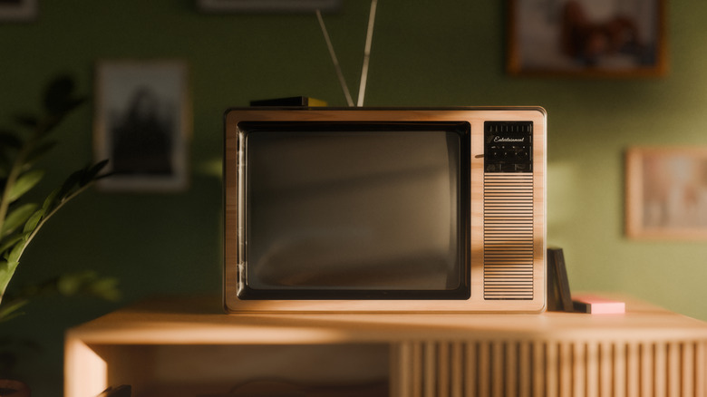 A vintage CRT TV on a wooden TV stand.