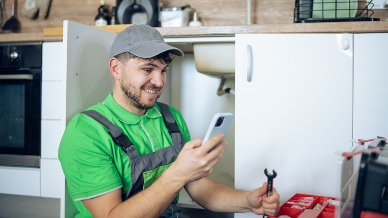 Plumber smiling at phone