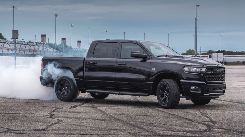 Black Ram 1500 doing a burnout, white smoke coming out of the rear tires.