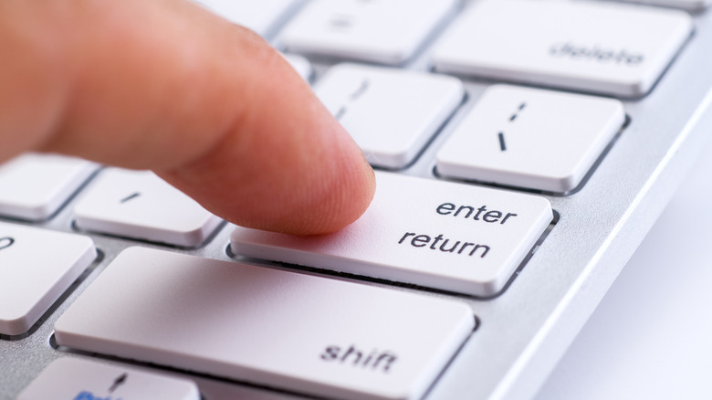 Finger pressing the enter key