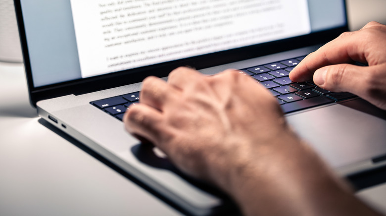 Person typing on laptop keyboard