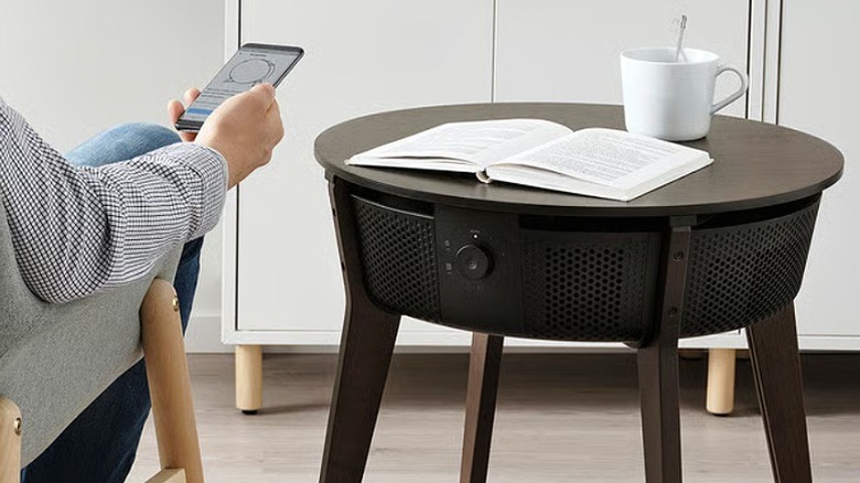 Brown air purifier table with cup and book placed on top