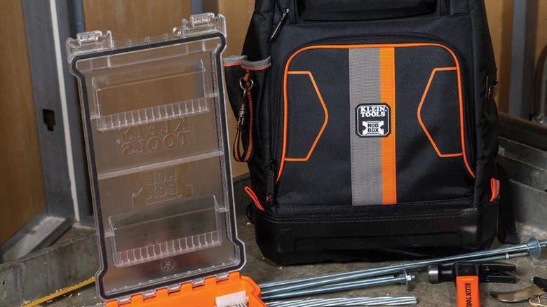 The Klein Tools Electrician Backpack standing next to the open lid of a Component Box, the body is out of frame