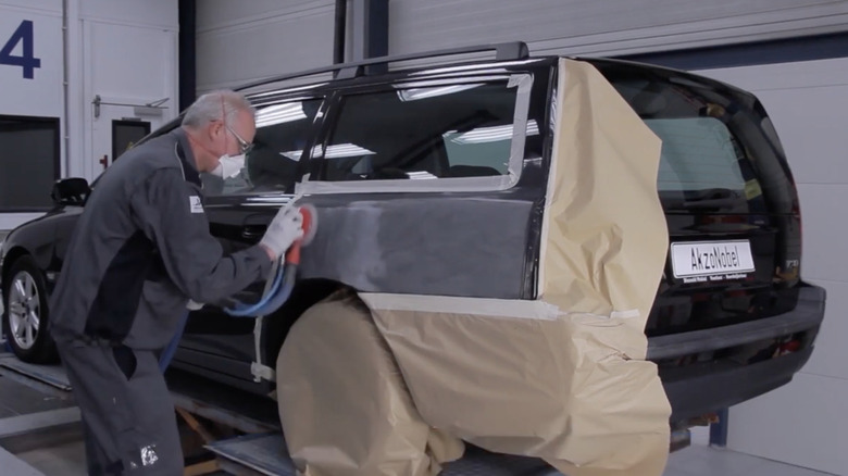 A man prepping the car to paint