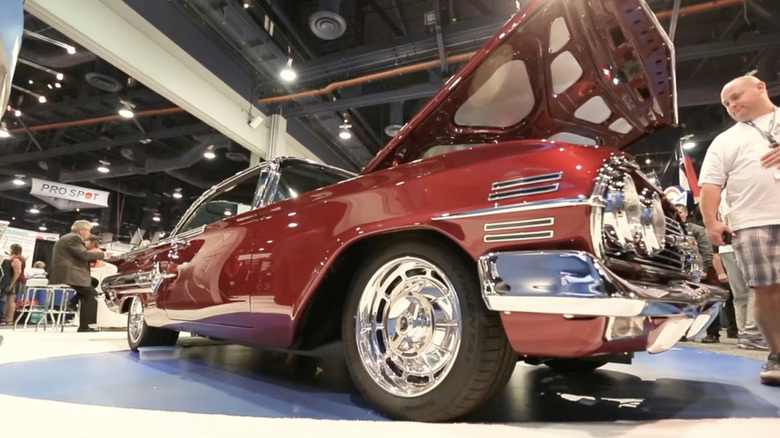 A classic red 1960 Impala on display at an auto show