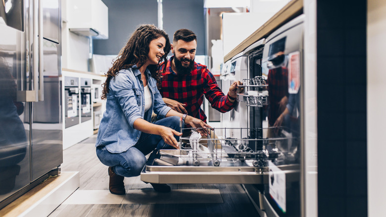 Couple looking at a dishwasher in an appliance store