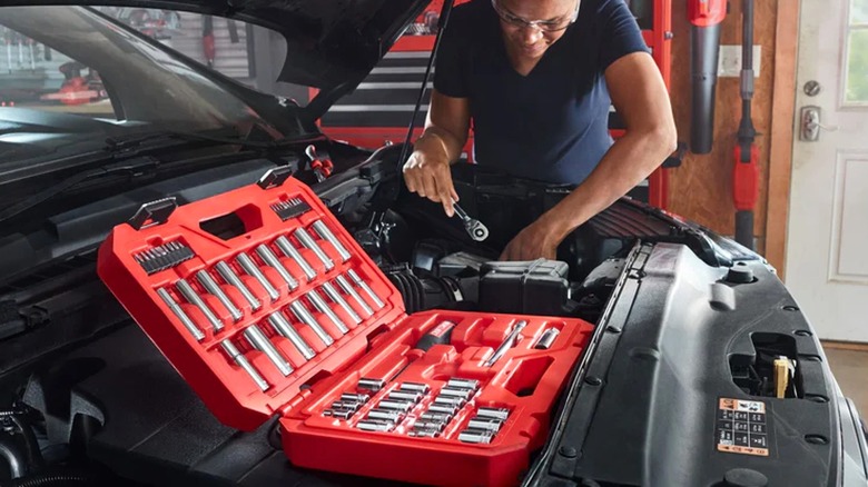 Mechanic using Craftsman socket set on car.