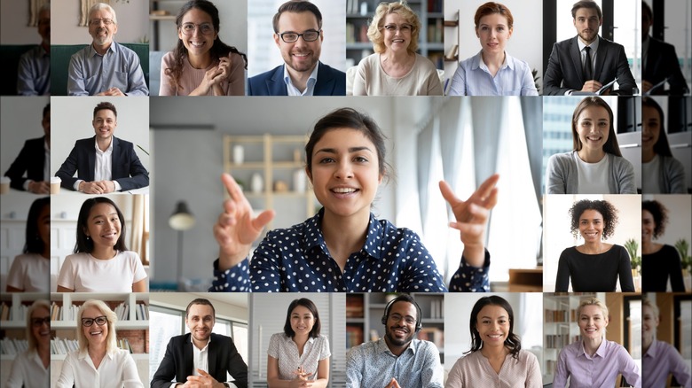 Webcam laptop screen view many faces of diverse people involved in group videoconference on-line meeting