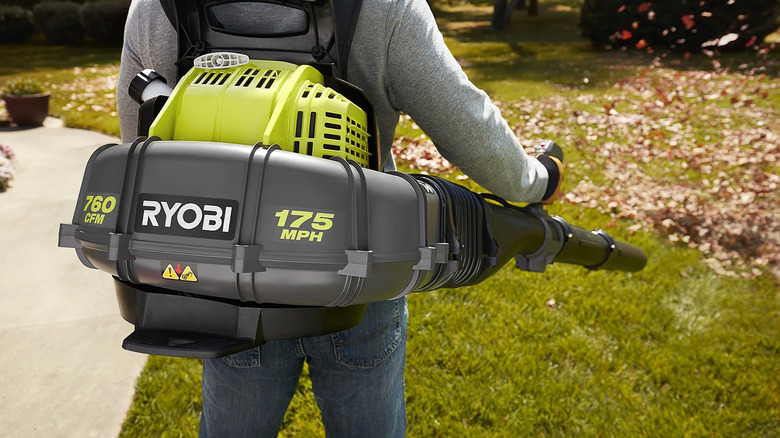A man using a Ryobi backpack leaf blower
