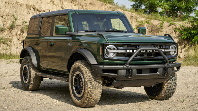 Green Ford Bronco parked in dirt