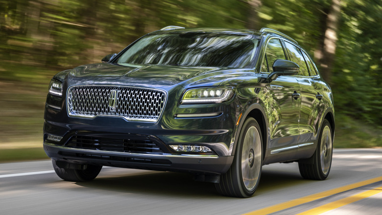 Blue Lincoln Nautlius driving on a forested road