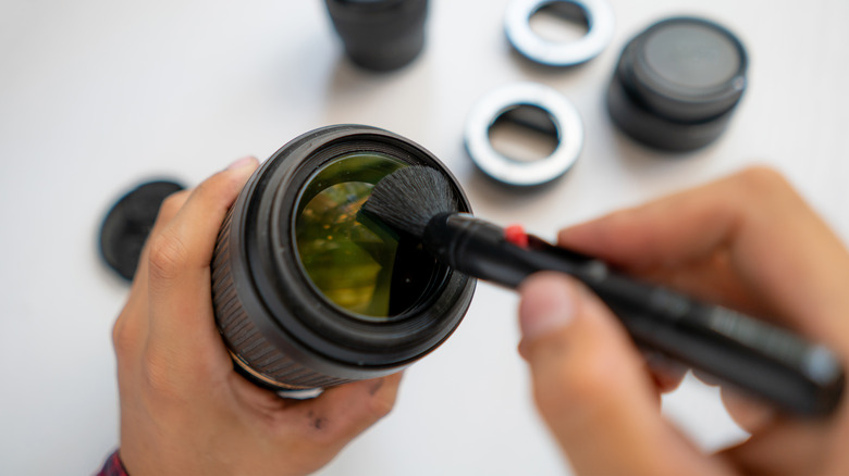 man cleaning camera lens