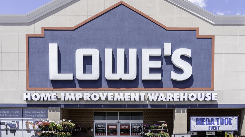 A Lowe's Home Improvement Warehouse storefront displaying a Mega Tool Event banner.