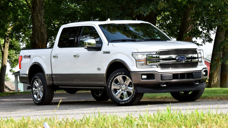 White 2018 Ford F-150 parked with trees and buildings in the background