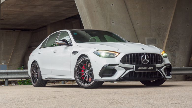 The latest Mercedes AMG C63 S E-Performance parked in front of an industrial-looking building.