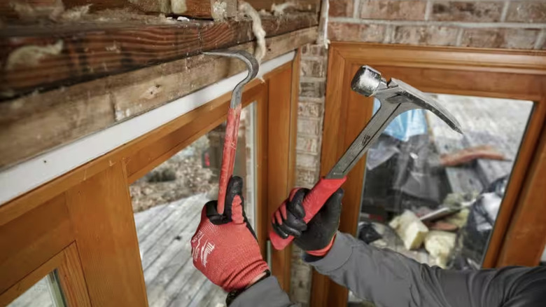 Person using hammer on crow bar