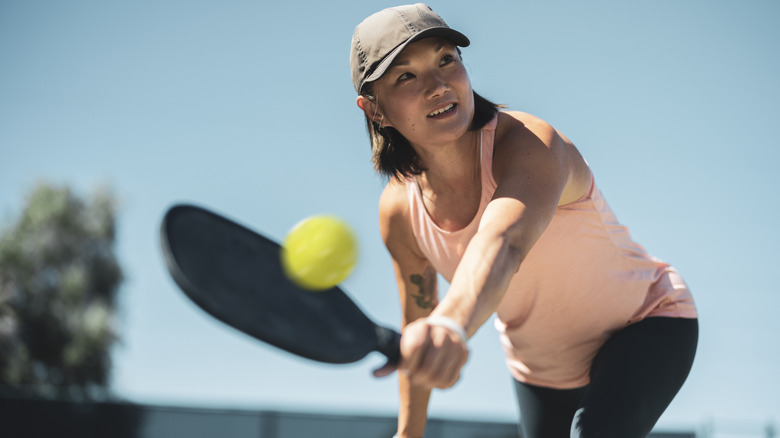 Woman hits backhand in pickleball