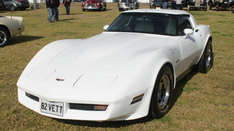 White 1982 Chevrolet Corvette parked on grass at a car show