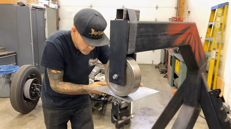 A man using a floor model English wheel