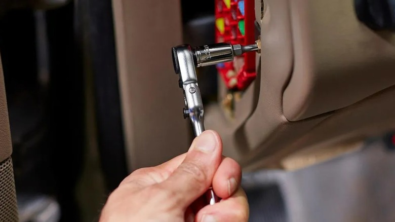 A person using an Icon socket wrench on a car.