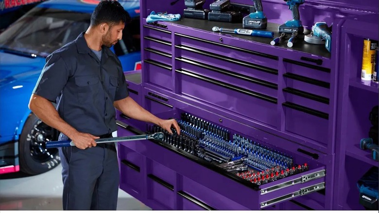 Person picking out a socket from a purple U.S. General Triple-bank Roll Cab