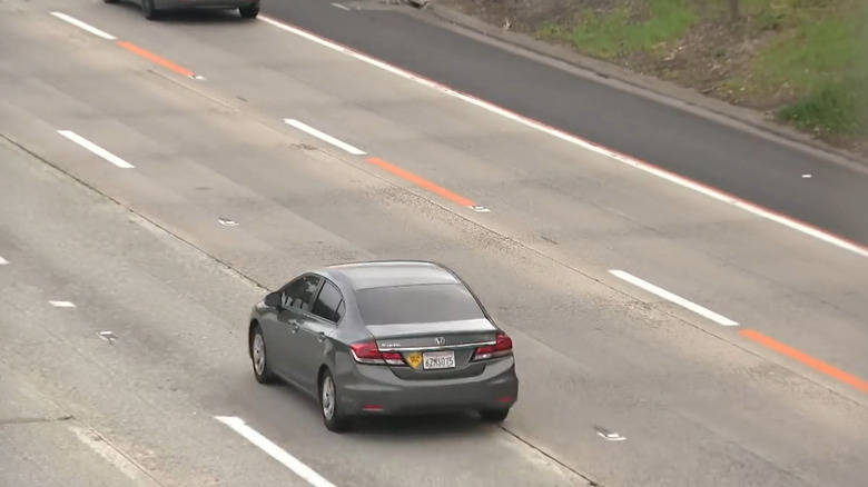Image of orange caution lines painted on a freeway in San Diego, California.