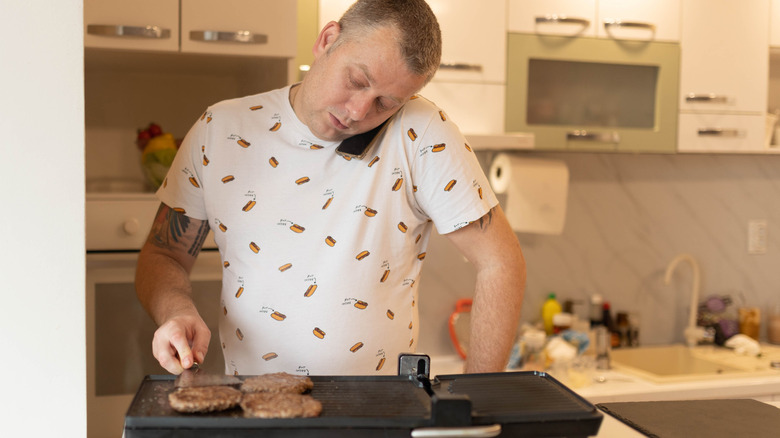Man cooking on an indoor electric girll