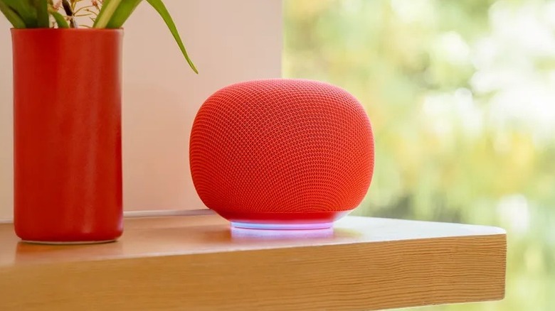 red Google Home Speaker on shelf next to red vase