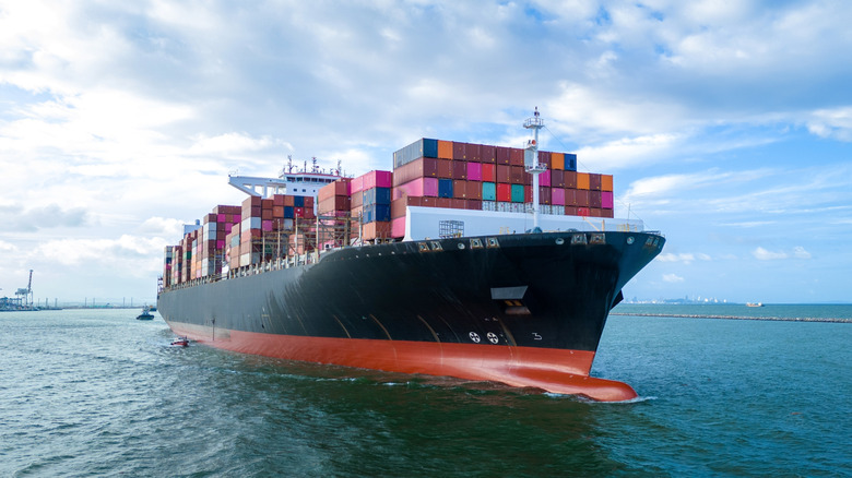 Front view of a ship carrying cargo on the water.
