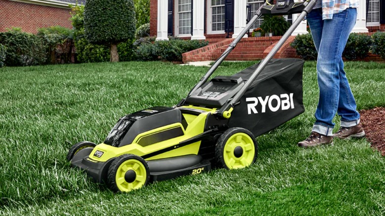 A person using a Ryobi lawn mower.