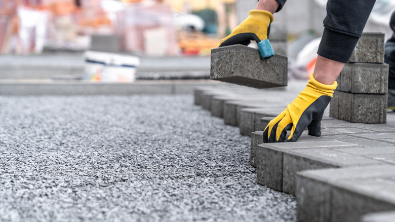 Worker installing tiles on a sidewalk