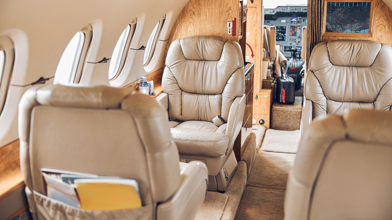 Plush interior of a private jet with the cockpit also visible