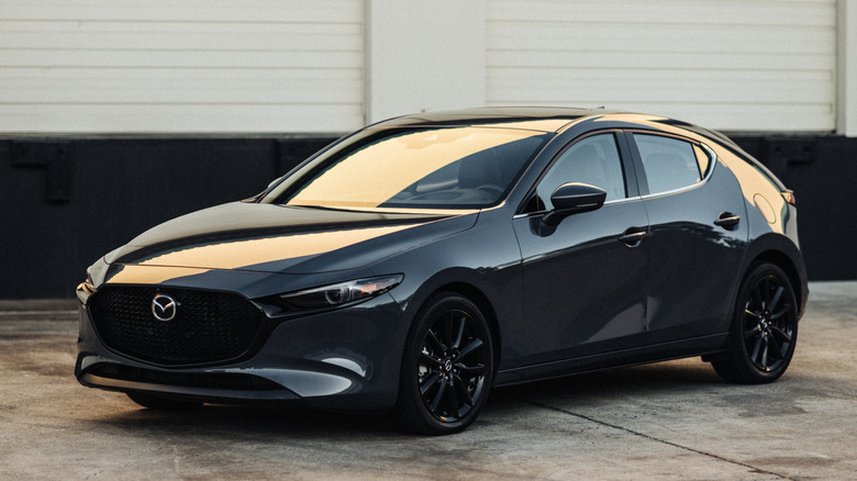 Front 3/4 view of gray Mazda3 hatchback in loading dock area