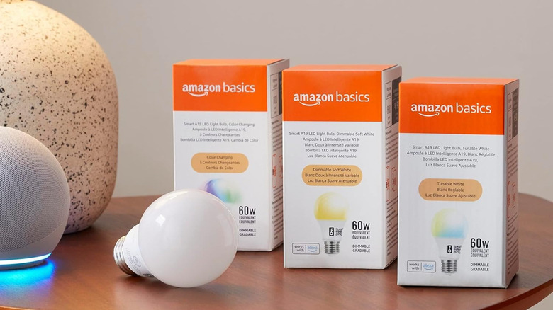 Amazon Basics Smart Light Bulb with three boxes on table with Amazon Echo speaker