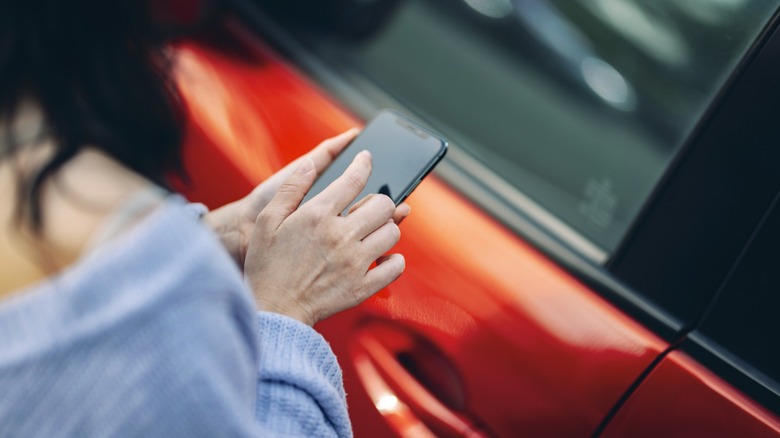 Person using an iPhone to unlock a car