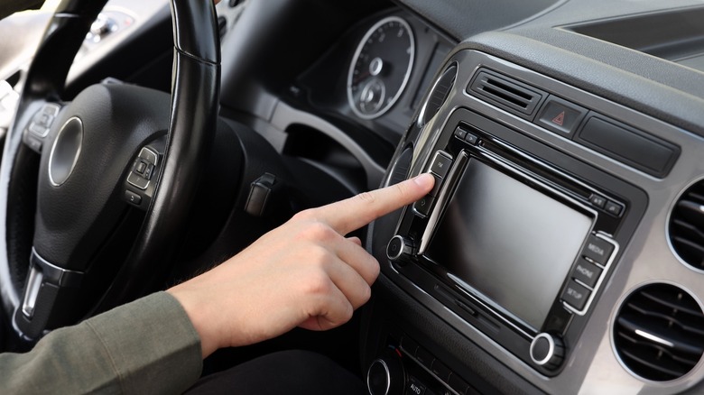 a person behind the wheel trying to operate a non-functional infotainment system