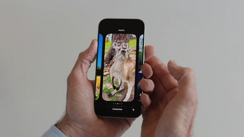 Hand holding iPhone while changing lock screen wallpaper to 3D Spatial Scene