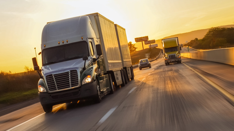 Trucks on a road at twilight.